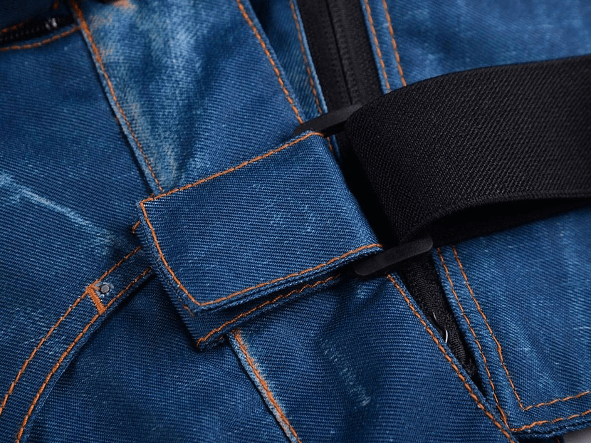Close-up of blue windproof thermal denim snowboard pants with suspenders and zipper. Ideal for cold weather skiing and snowboarding.